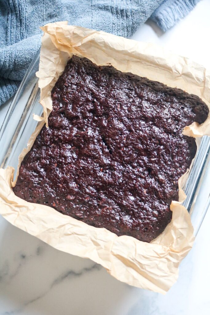 finished zucchini brownies in pan with parchment paper