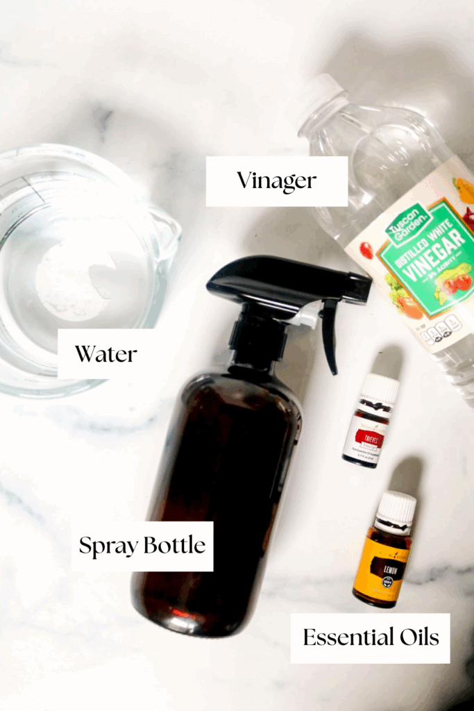 DIY multi purpose cleaner spray bottle with vinegar bottle, essential oils and bowl of water