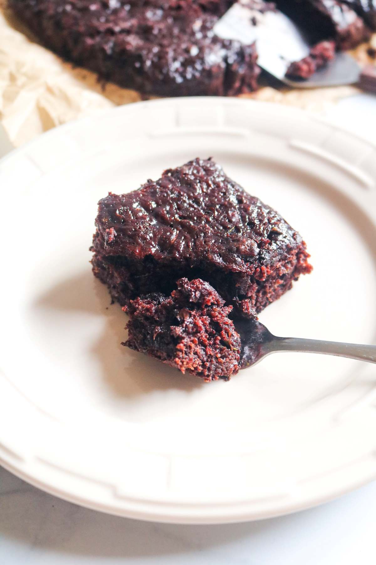 zucchini brownies on white plate with fork