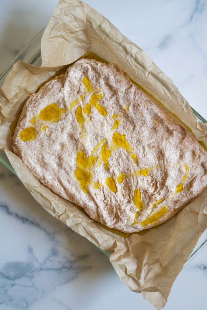 focaccia bread with olive oil drizzled on top in baking dish