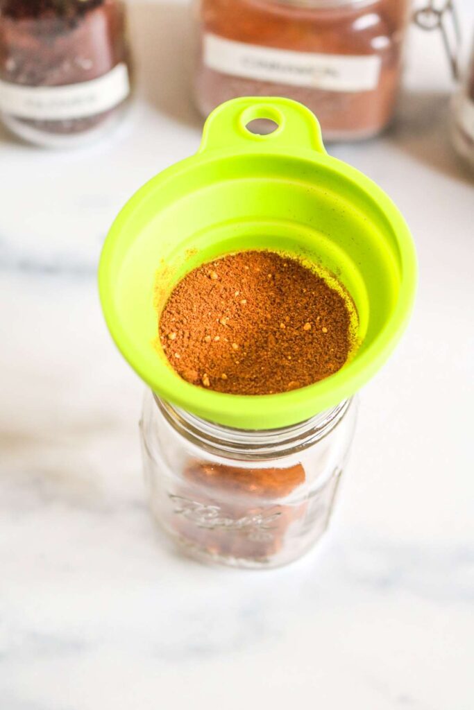 green funnel over mason jar with pumpkin pie spice at the top